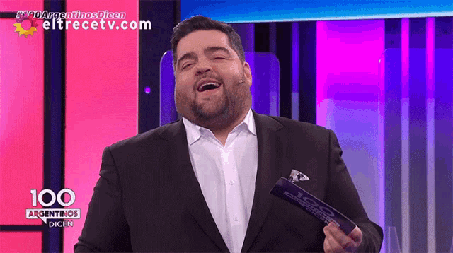 a man in a suit is holding a trophy that says 100 argentinas dicen