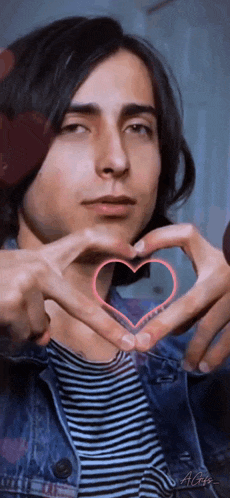 a young man making a heart shape with his hands .