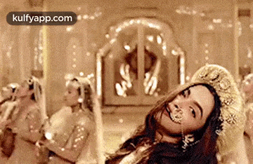 a woman is dancing in front of a group of women in a room .