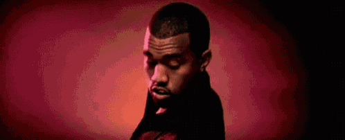 a close up of a man 's face with a red background and a red light behind him .