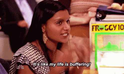 a woman is sitting at a table in front of a machine that says `` it 's like my life is buffering '' .