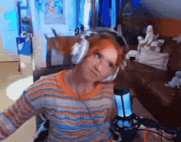 a woman wearing headphones sitting in front of a microphone in a living room .