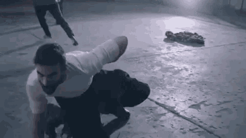 a man with a prosthetic leg is doing a handstand on the floor .