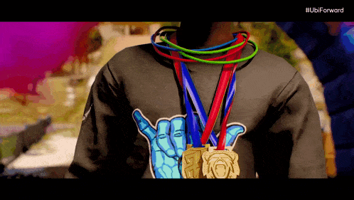 a man wearing a black shirt with a hand on it is holding a bunch of medals
