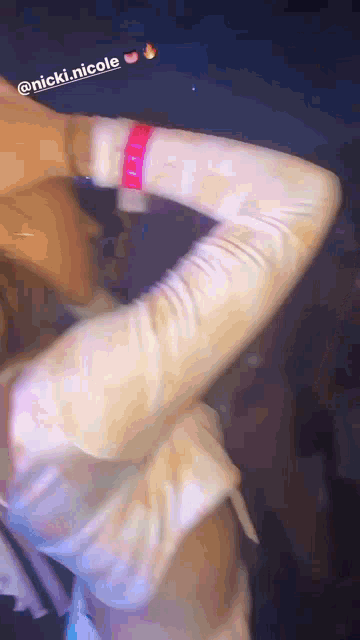 a blurry photo of a person with the name nicki nicole on the bottom left