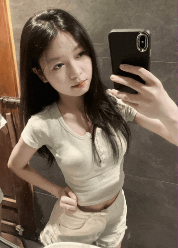 a girl taking a picture of herself in a mirror