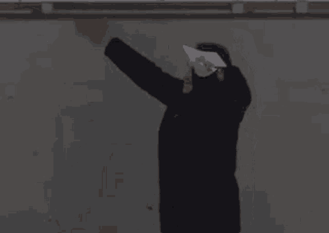 a man wearing a mask is hugging another man while holding a knife in his hand .