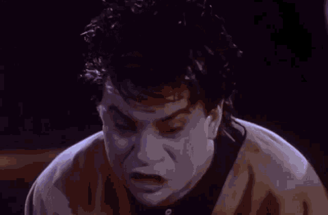 a close up of a person screaming with their mouth open .
