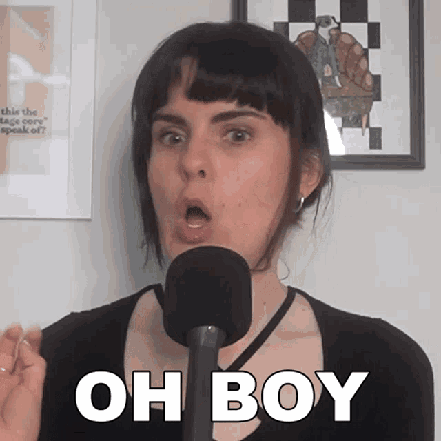 a woman is speaking into a microphone and the words oh boy are on the screen