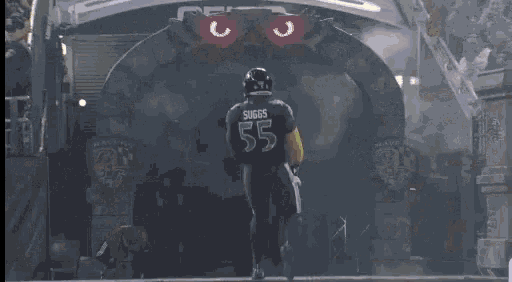 a football player with the number 55 on his jersey stands in the tunnel