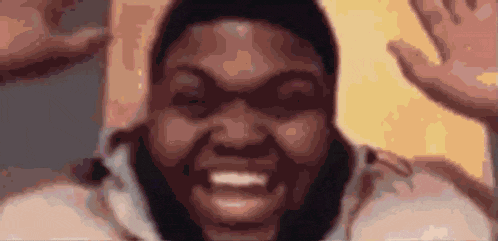 a close up of a man 's face with his hands in the air and a smile on his face .