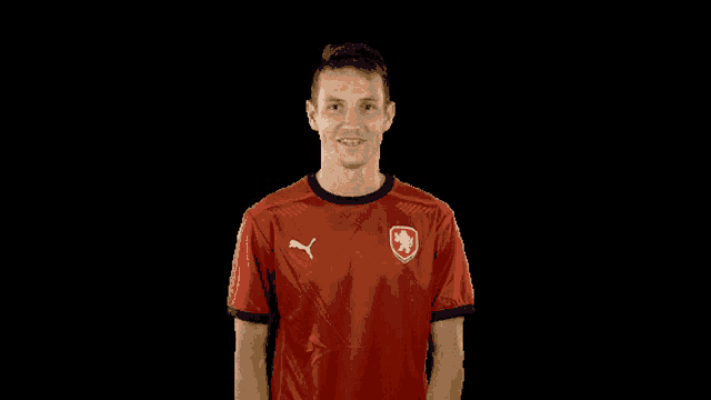 a man in a red shirt with a puma logo on the front