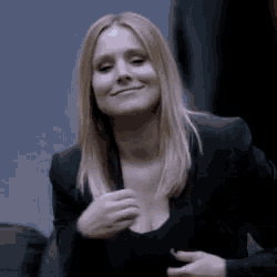 a woman wearing a black jacket and a black shirt is smiling