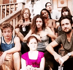 a group of people sitting on a set of stairs with one woman wearing a pink shirt