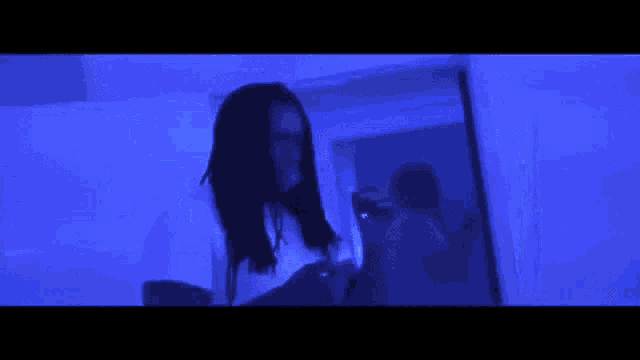 a blurry picture of a person standing in front of a blue wall