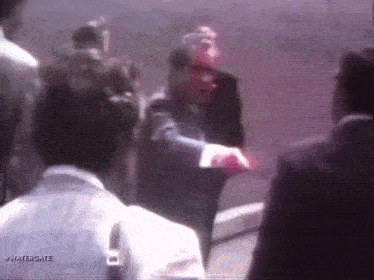 a man in a suit is talking to another man in a white shirt with the words watergate on the bottom