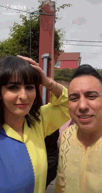 a man and a woman are posing for a picture with tiktok written on the bottom right