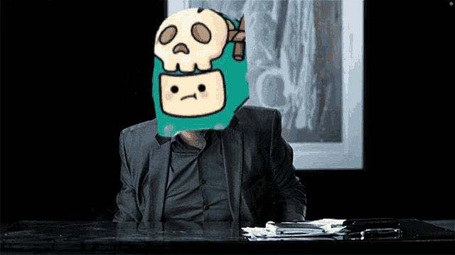 a man sits at a desk with a cartoon character on his head