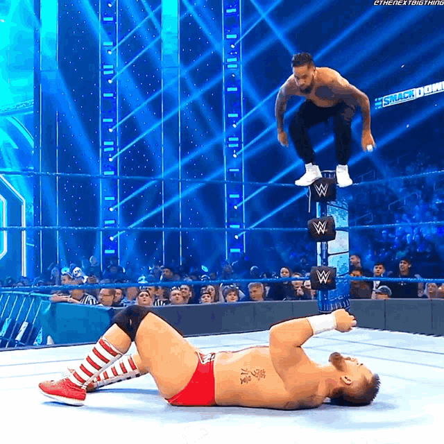 a wrestler is jumping over another wrestler in a wrestling match