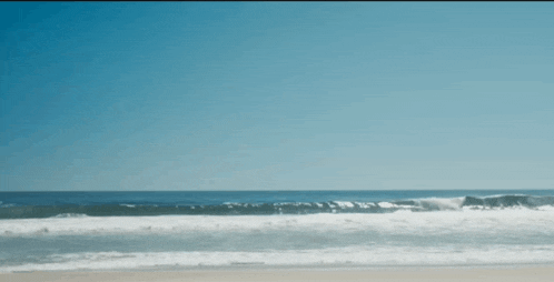 a blurry picture of a beach with waves crashing on the shore