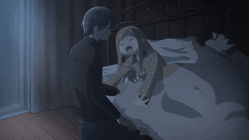a man sits next to a girl who is laying in bed