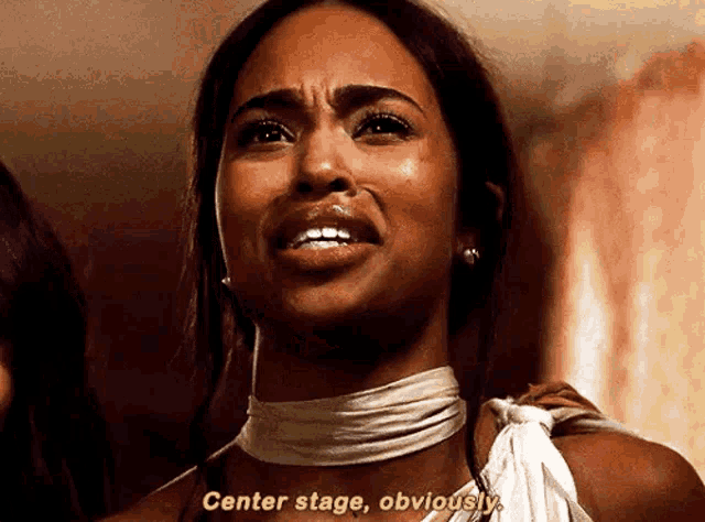 a woman in a white dress is crying and saying `` center stage , obviously . ''