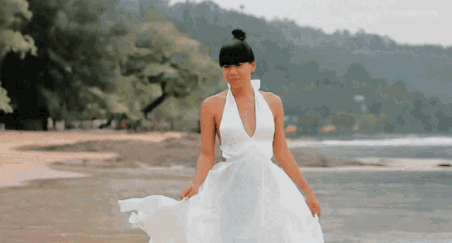 a woman in a white dress is standing on a beach with a caption that says yourtype