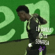 a soccer player is dancing in front of a green sign that says la danza de la sonrisa