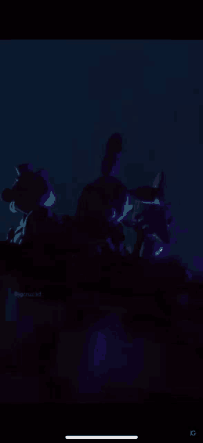 a bunch of stuffed animals are glowing in the dark in a dark room .