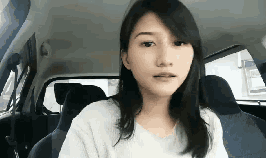 a young woman is sitting in the back seat of a car .
