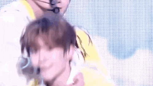 a man is holding another man 's head in his arms while they are dancing on a stage .
