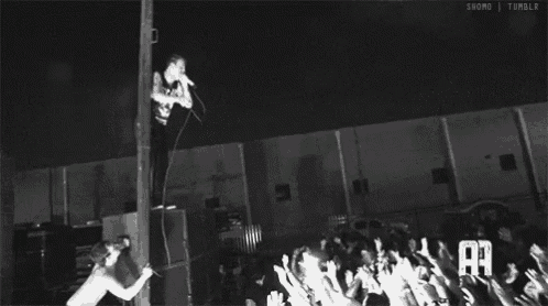 a black and white photo of a man hanging from a pole with the letters aa on the bottom