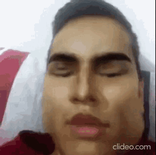 a close up of a man laying in bed with his eyes closed .