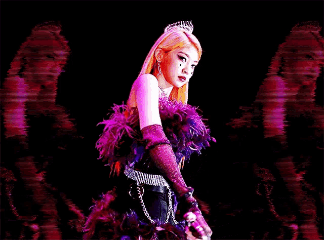 a woman in a purple feathered dress is holding a sword in her hand .