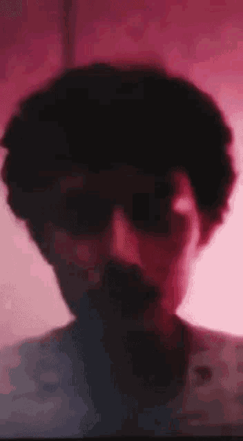 a close up of a man 's face with sunglasses and a mustache .