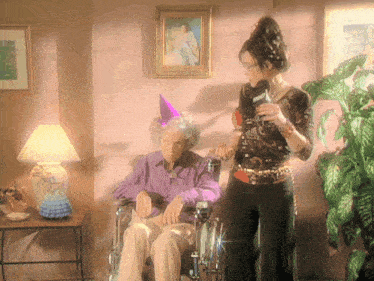 an elderly woman in a wheelchair is being interviewed by a woman wearing a microphone