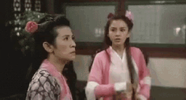 two women are standing next to each other in a room .