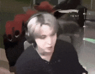 a man wearing headphones is sitting in front of a computer monitor .