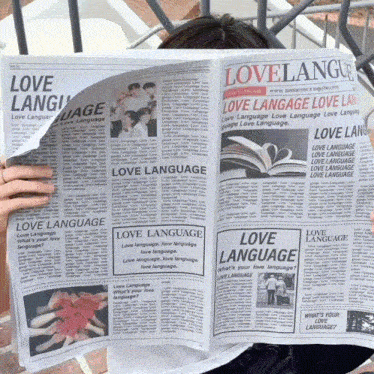 a woman is reading a newspaper that says love language