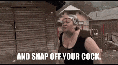 a woman is standing in front of a wooden building with the words `` and snap off your cock '' written on the screen .