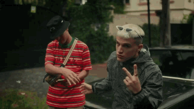 two young men are standing next to each other and one of them is wearing sunglasses