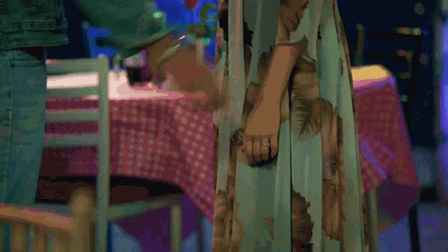 a woman is standing in front of a table with a pink table cloth