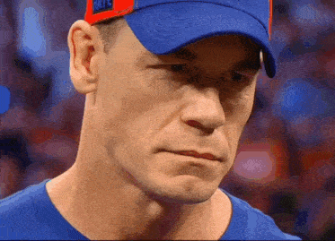 a close up of a man wearing a blue shirt and a blue hat that says phillies on it