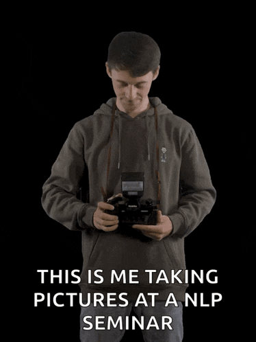 a man is taking pictures at a nlp seminar with his arms outstretched .
