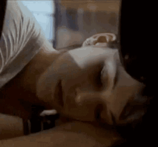 a close up of a woman laying down with her head on a man 's chest .