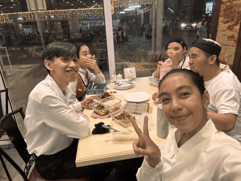 a group of people sitting at a table with a sign that says ' a ' on it