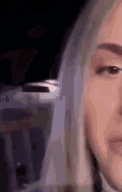 a close up of a woman 's face in a dark room .