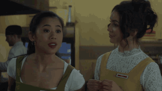 two women are standing next to each other and one of them is saying yes absolutely yes