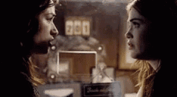 two women are standing next to each other in a dark room .