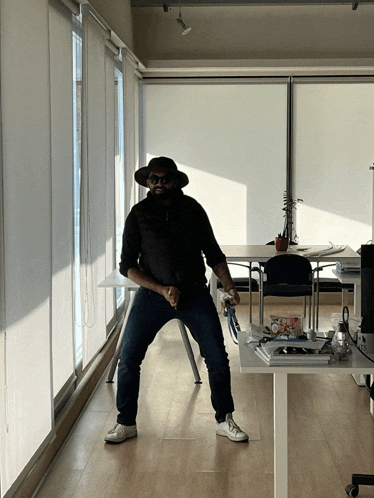 a man wearing a hat and sunglasses stands in a room